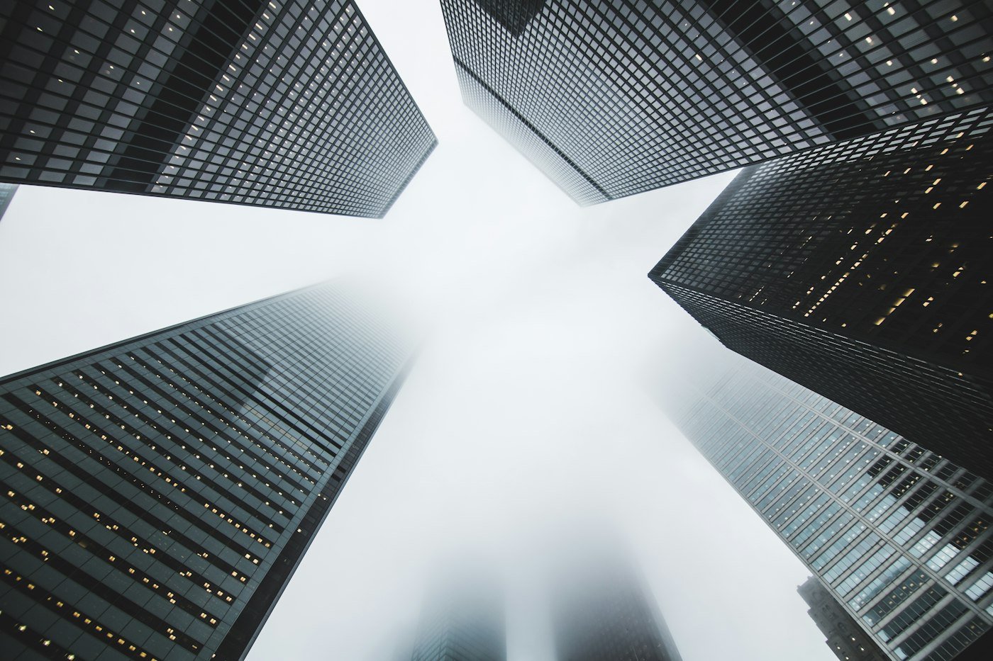 Looking up at city skyscrapers in the fog